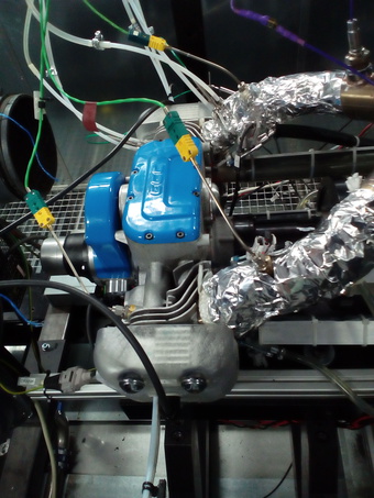 Engine of the range extender at the test facilities of ESS Automotive. The blue cover conceals the central section of the engine; in the foreground are the front cyl